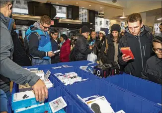  ?? CALLA KESSLER / THE NEW YORK TIMES ?? Black Friday shoppers flocked to Best Buy on Fifth Avenue in New York the day after Thanksgivi­ng, but the overall number of shoppers at brick-and-mortar retail stores dipped.
