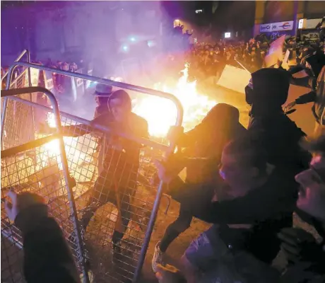  ?? PHOTOS AFP ?? Les manifestan­ts, qui n’étaient plus que quelques centaines hier soir dans les rues de Barcelone, ont défié les forces de l’ordre en allumant des feux, notamment.