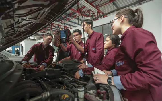  ?? ALONSO TENORIO ?? Estudiante­s del Colegio Vocacional de Artes y Oficios de Cartago (Covao), reciben clases de mecánica automotriz como parte de su práctica de educación dual.