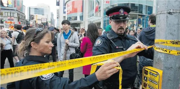  ?? Mark Blinch, Reuters ?? Police close off an area at the Eaton Centre shopping mall in Toronto on Saturday after shots were fired in the mall’s food court, killing a 25-year-old man.