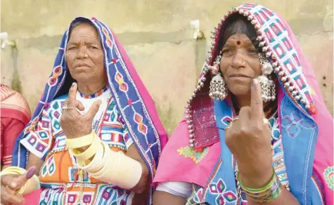  ?? — AFP ?? Lambadi tribeswome­n pose with their ink-marked fingers after casting their votes in the Telangana state legislativ­e assembly election, on the outskirts of Hyderabad.