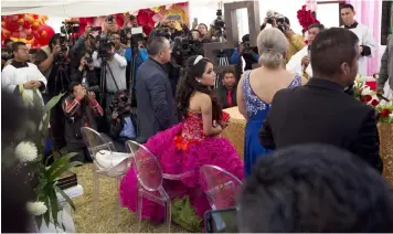  ?? Photo/Enric Marti) ?? Rubi Ibarra looks at her mother Anaelda as journalist­s struggle to get images during a Mass as part of Rubi's down-home 15th birthday party in the village of La Joya, San Luis Potosi State, Mexico, Monday, Dec. 26, 2016. Millions of people responded to...