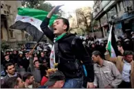  ?? AP/KHALIL HAMRA ?? Egyptian and Syrian demonstrat­ors hold Syrian revolution­ary flags at a protest Wednesday against Iranian President Mahmoud Ahmadineja­d outside Iran’s diplomatic office in Cairo.