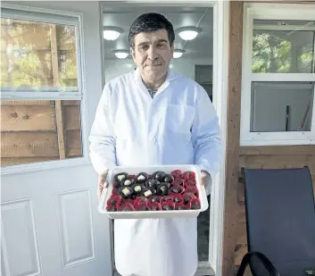  ?? ANDREW VAUGHAN/CANADIAN PRESS ?? Assam Hadhad, a Syrian refugee who arrived in Canada last year, displays a tray of chocolates at his shop, Peace by Chocolate, in Antigonish, N.S. on Wednesday. Prime Minister Justin Trudeau shared the story of the Hadhad family as he addressed a...