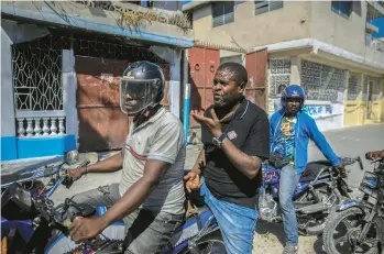  ?? ODELYN JOSEPH/AP ?? Jimmy “Barbecue” Cherizier, the leader of the G9 Family and Allies gang, talks with members of his gang Jan. 24 while taking a ride in Port-au-Prince, Haiti. Cherizier says he’s a “revolution­ary,” advocating against a corrupt government.