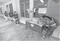  ?? (Juan Carlo de Vela) ?? READY FOR SCHOOL – Parents line up on the corridor of Guadalupe National School in Cebu City on Monday, September 28, to claim the dry run worksheets of their children that will be used during the modular and online learning that will start October 5.