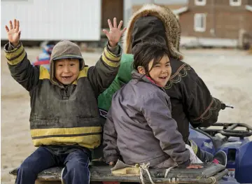  ??  ?? Ladanian Ikuallaq (left) and Puyuaq Uttaq ride through Gjoa Haven on an ATV.