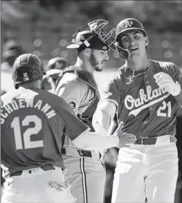  ?? Godofredo A. Vásquez Associated Press ?? TYLER SODERSTROM, right, slaps hands with teammate Max Schuemann after hitting a home run against the Rangers. The A’s, who were 18-21 entering Friday, are moving to Sacramento, and eventually to Las Vegas, after this season.