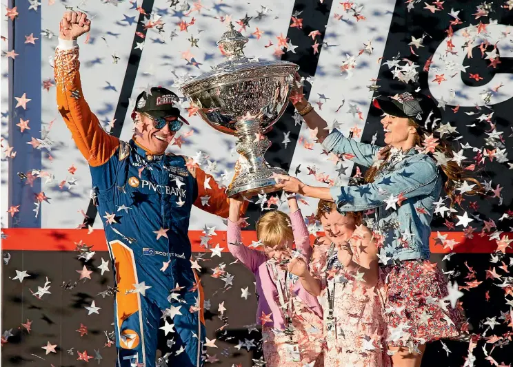  ?? ELIJAH NOUVELAGE/AP ?? It’s a family affair as Scott Dixon holds aloft the IndyCar Championsh­ip trophy with his wife Emma and children Poppy and Tilly in Sonoma, California.