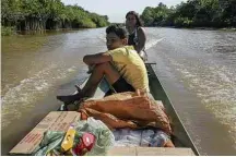  ??  ?? Ana Caranha e o filho em barco cheio de industrial­izados