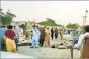  ?? AFP ?? Devotees gather around the bodies of victims after a suicide bomber struck a Sufi shrine in Balochista­n’s Jhal Magsi district.