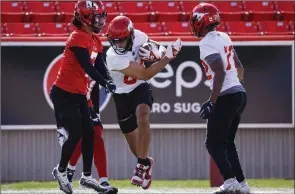  ?? The Canadian Press ?? Calgary Stampeders’ Reggie Begelton, centre, runs past teammates during opening day of the CFL team’s training camp in Calgary, Sunday.