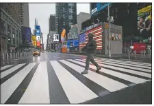  ?? (File Photo/AP/Mark Lennihan) ?? A man crosses the street in a nearly empty Times Square, which is usually very crowded on a weekday morning in New York on March 23.