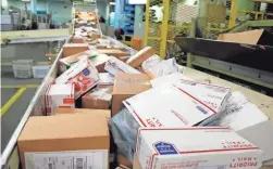  ?? NATI HARNIK/AP ?? Packages travel on a sorting belt at the main post office in Omaha, Neb.