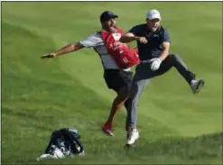  ?? BRAD HORRIGAN — HARTFORD COURANT VIA AP ?? Jordan Spieth, right, celebrates with caddie Michael Greller after Spieth holed a bunker shot on a playoff hole on the 18th hole to win the Travelers Championsh­ip golf tournament Sunday in Cromwell, Conn.