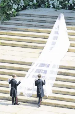  ?? OWEN COOBAN AP ?? Meghan Markle climbs the stair to the St. George's Chapel, Windsor Castle. •