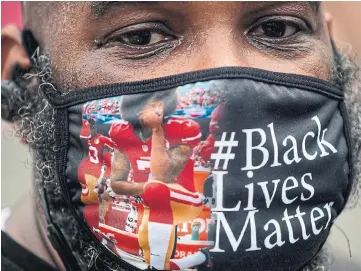  ?? ROBERTO SCHMIDT AFP VIA GETTY IMAGES ?? A protester, wearing a face mask featuring
Colin Kaepernick kneeling, joins a protest in Washington against racism and police brutality on Saturday.