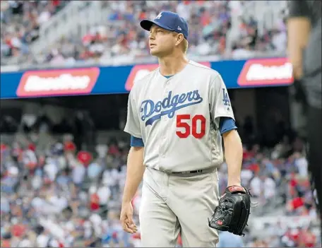  ?? Wally Skalij Los Angeles Times ?? RYAN MADSON, who entered the game with the bases loaded in the fifth, walks off the field after getting the Dodgers out of the jam.