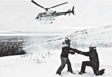  ?? MIKE ROYER/RUBY MOUNTAINS HELICOPTER EXPERIENCE ?? Avery proposes to Whiting while helicopter skiing in Nevada’s Ruby Mountains on Feb. 6. The two had been planning a 300-person wedding but instead have decided to marry June 6 in their Northern California backyard.