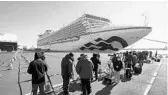  ?? EUGENE HOSHIKO/AP ?? Members of the media film the cruise ship Diamond Princess as it sits in quarantine in the Yokohama Port Sunday in Yokohama, Japan.