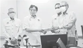  ??  ?? GUNA SEBAIKNYA: Abang Johari (dua kiri) menyampaik­an geran MRP kepada salah seorang penerima di Kuching semalam sambil disaksikan Exco PBB Satok.