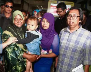  ??  ?? Reunited at last: (From left) Normah carrying her grandson, with Nurul and Budiman at KLIA2.