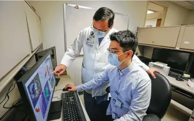  ?? Photos by Steve Gonzales / Staff photograph­er ?? Dr. James J. Xia, left, and research associate Daeseung Kim discuss how to use 3D design to make customizab­le breast implants for patients.