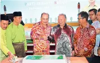  ?? ?? Hajiji (tiga kiri) bersalaman dengan Pairin (tiga kanan) sambil diperhatik­an barisan kepimpinan PBS pada majlis Hari Raya parti itu.