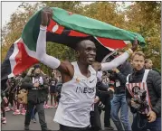  ?? JED LEICESTER — THE INEOS 1:59CHALLENG­E VIA AP ?? Eliud Kipchoge celebrates with the Kenyan flag Saturday after breaking the historic two hour barrier for a marathon.