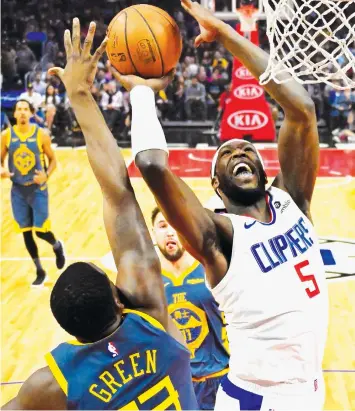  ??  ?? Los Angeles Clippers forward Montrezl Harrell, right, shoots as Golden State Warriors forward Draymond Green defends during the first half of an NBA basketball game in Los Angeles.ASSOCIATED PRESS