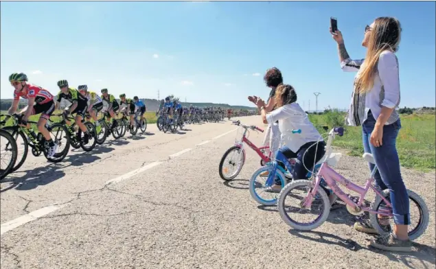  ??  ?? EXPECTACIÓ­N EN LA CARRETERA. Tres aficionada­s, con tres bicicletas de tamaño infantil, se acercaron ayer a saludar y fotografia­r al pelotón de la Vuelta.