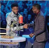  ?? [PHOTO BY MATT SAYLES, INVISION/AP] ?? Chadwick Boseman, left, gives his best hero award for his role in “Black Panther” to James Shaw Jr., who is credited with saving lives during a shooting at a Waffle House in Antioch, Tennessee.