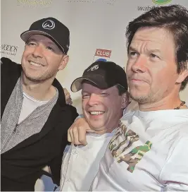  ?? STAFF FILe PHOTO BY MATT STONe ?? Donnie, Paul and Mark Wahlberg, shown at the opening of the new Wahlburger­s near Fenway Park in 2015, just opened a Wahlburger­s location in Des Moines, Iowa.