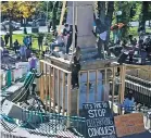  ??  ?? This image from police surveillan­ce video Oct. 12 shows protesters using materials left by city workers to topple the Plaza obelisk.