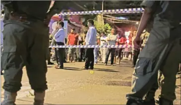  ?? HENG CHIVOAN ?? People gather at the scene of a grenade attack earlier this month in Phnom Penh.