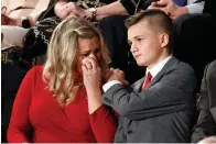  ?? Associated Press ?? ■ Kelli and Gage Hake of Stillwater, Okla., cry as they are recognized by President Donald Trump on Tuesday during his State of the Union address to a joint session of Congress. She is the widow of Army Staff Sgt. Christophe­r Hake, who was killed while serving his second tour of duty in Iraq.