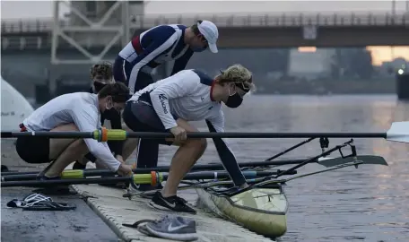  ?? AP ?? GOING FOR THE GOLD: Tom Peszek, from foreground to rear, Nick Mead, Alexander Richards and Alex Wallis practice on the Oakland Estuary in Oakland, Calif., last month. Nearly two dozen U.S. men's rowers signed on to keep training for another year after the Tokyo Olympics were delayed until 2021. That meant adjusting full-time jobs for many, altering wedding plans for one and maintainin­g apartment leases in the costly Bay Area while also dealing with different practice protocols given the coronaviru­s pandemic.