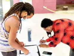  ??  ?? Zack Horsley registered to vote as organizer Blair Edwards helps with paperwork (Photo by Ryan Phillips, SDN)
