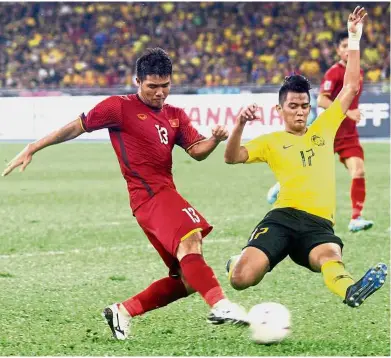  ?? — M. AZHAR ARIF/ The Star ?? Back off: Malaysia’s Irfan Zakaria (right) in action against Vietnam’s Ha Duc Chinh during the first leg of the AFF Suzuki Cup final at the National Stadium in Bukit Jalil yesterday.