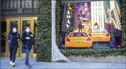  ?? ASSOCIATED PRESS ?? Black Friday shoppers wear face masks as they leave Saks Fifth Avenue flagships store empty handed Friday in New York.