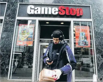  ?? CARLO ALLEGRI / REUTERS ?? Un repartidor preparando un paquete a la salida de un establecim­iento Gamestop de Nueva York