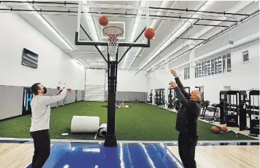  ?? CLIFFORD SKARSTEDT EXAMINER ?? Hybrid Sports co-owners Josh Gillam, left, and Gregory Couch shoot hoops Wednesday during a tour of the new junior basketball courts and turf field being completed inside the former Rona building centre on Chemong Road.