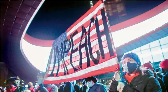  ?? — AFP ?? Demonstrat­ors hold a banner calling for impeachmen­t of US President Donald Trump during a protest outside the Barclays Centre in Brooklyn, New York on Thursday, a day after pro- Trump mob stormed and trashed the Capitol.