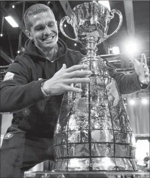  ?? CP PHOTO ?? Ottawa Redblacks quarterbac­k Trevor Harris poses with the Grey Cup during Grey Cup media day Thursday in Edmonton. The Redblacks will play the Calgary Stampeders in the 106th Grey Cup game on Sunday.