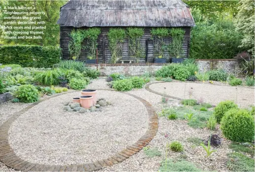  ??  ?? A black barn on a neighbouri­ng property overlooks the gravel garden decorated with brick ovals and planted with creeping thymes, alliums and box balls