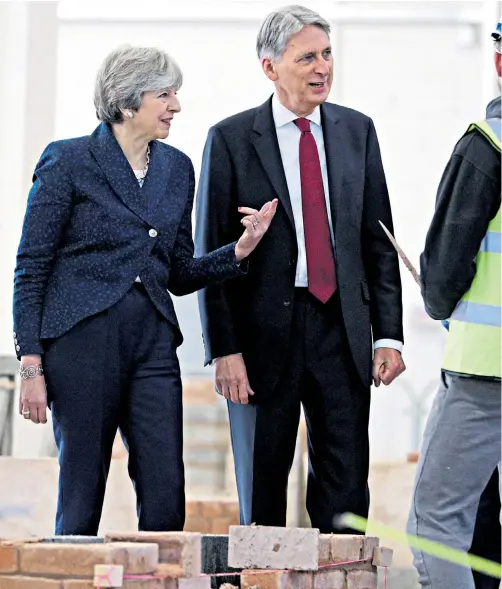  ??  ?? Theresa May and Philip Hammond put on a united front as they visited Leeds College of Building yesterday