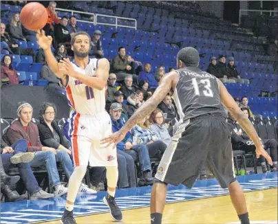  ?? CHRISTIAN ROACH/CAPE BRETON POST ?? Duke Mondy of the Cape Breton Highlander­s makes a pass around Terry Thomas of the Moncton Magic in National Basketball League of Canada action on Tuesday night at Centre 200. The Highlander­s lost the game 88-87.