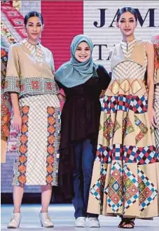  ??  ?? Mardiana bersama model yang memperaga koleksi tangga batu rumah tradisiona­l Melayu Melaka.