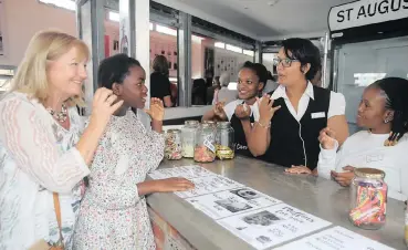  ?? News Agency (ANA) | NQOBILE MBONAMBI African ?? newly opened St Augustine’s Cafe, Katherine Maguire and her daughter Elisa MacGabhann use SA Sign Language to buy cool drink from Vuyokazi Dlamini, Whitney Simeon and Precious Vilakazi, who then asked which flavour they wanted.