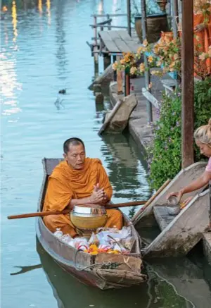  ??  ?? In alto, a sinistra, il rooftop del Lebua Hotel a Bangkok, reso celebre dal film Una notte da leoni, di Todd Phillips (2009); a destra, un monaco riceve offerte all’alba sul Mae Klong, a Bangkok.